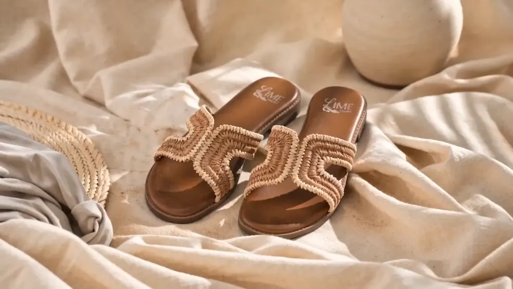 Cinematic AI product ad frame: macro shot of a woven raffia sandal strap in warm light