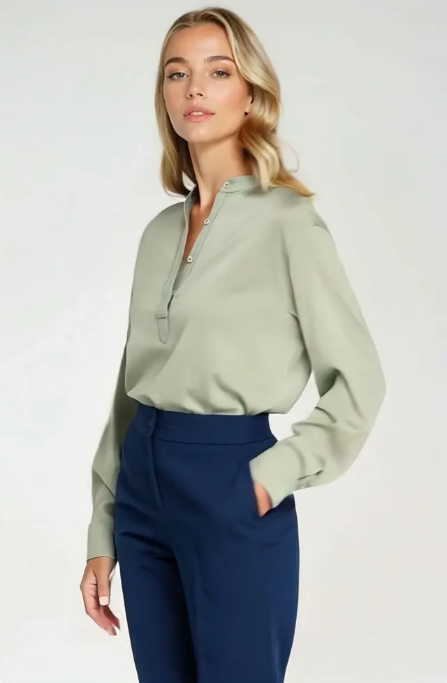 AI fashion video ad: a model in a sage blouse and navy trousers photographed in profile