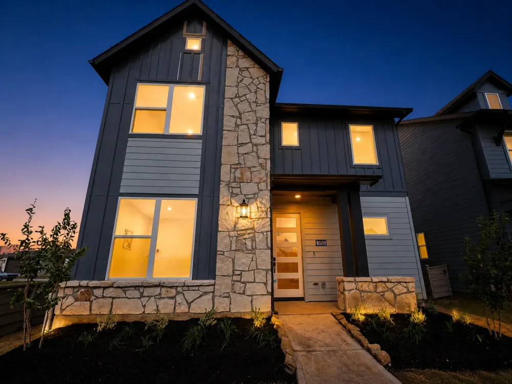 AI day-to-dusk edit: the same house at twilight with warm lit windows and a deep blue sky